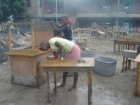 Ladies washing school desks and tables