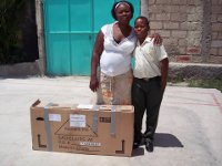 Roody Etienne and his mother receiving the package sent by his sponsor