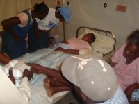 Murielle (left) and Mrs. Jean Gilles (right) speaking to a victim at the hospital