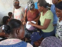 Bea (center in brown) and Gine filling up a bag for a victim